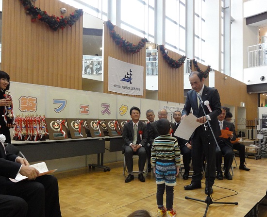 児童絵画コンクールで表彰する佐野会長