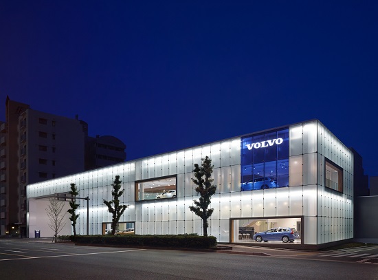 夜景/光の「ガラスキューブ」から、企業ロゴと縁取られた展示車が浮かびあがる